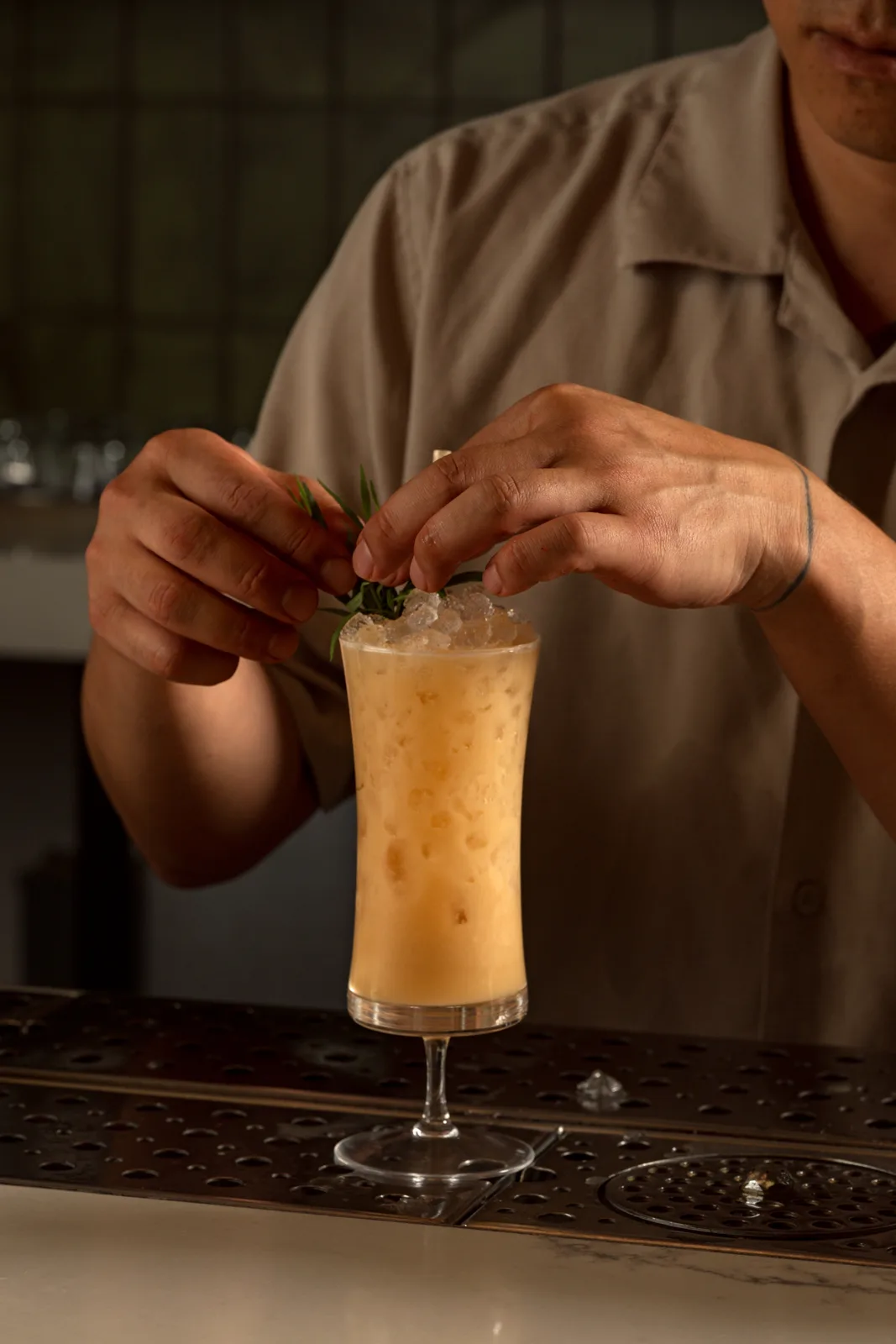 Garnishing a tall cocktail behind the bar